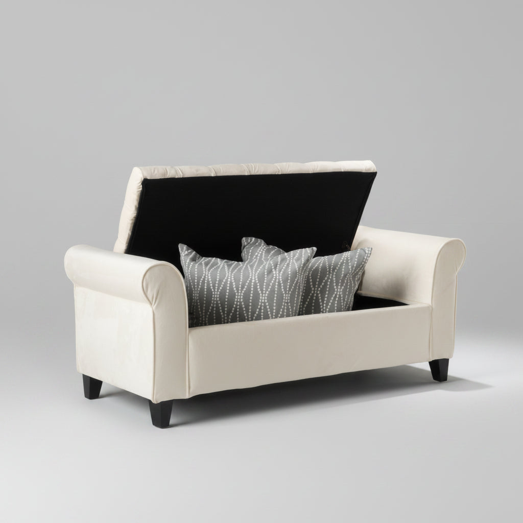 White sofa with black backrest and gray patterned pillow against a gray wall with abstract art.